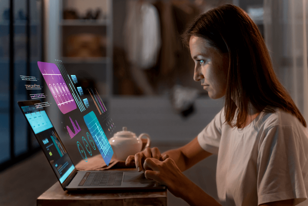 Track 2 - The Digital Transformation Remix Woman working on a laptop displaying futuristic data visualizations and analytics, representing digital transformation strategies.